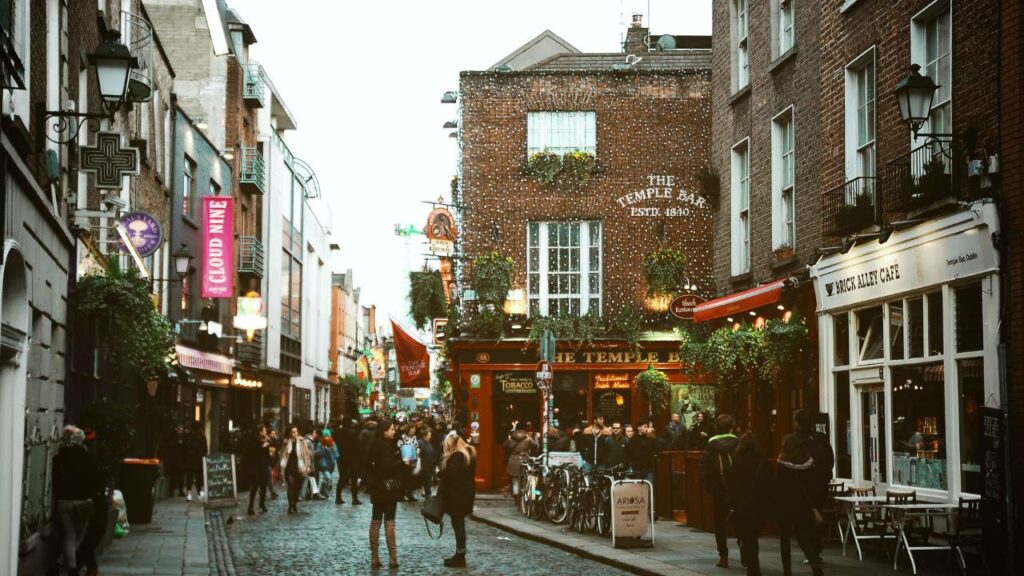 Street of an Irish city full of people and cafes
