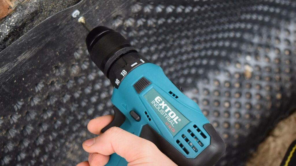 A blue cordless drill being used